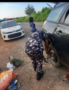 A policeman helping to change the tyre of the distressed man