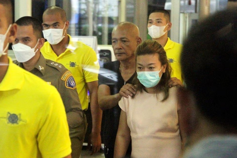 Sararat Rangsiwuthaporn, a suspect in over a dozen murders, is escorted by police officers at a police station in Bangkok, Thailand, April 26, 2023. Daily News Handout via REUTERS